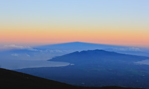 На горизонте видно тень от вулкана в форме треугольника.